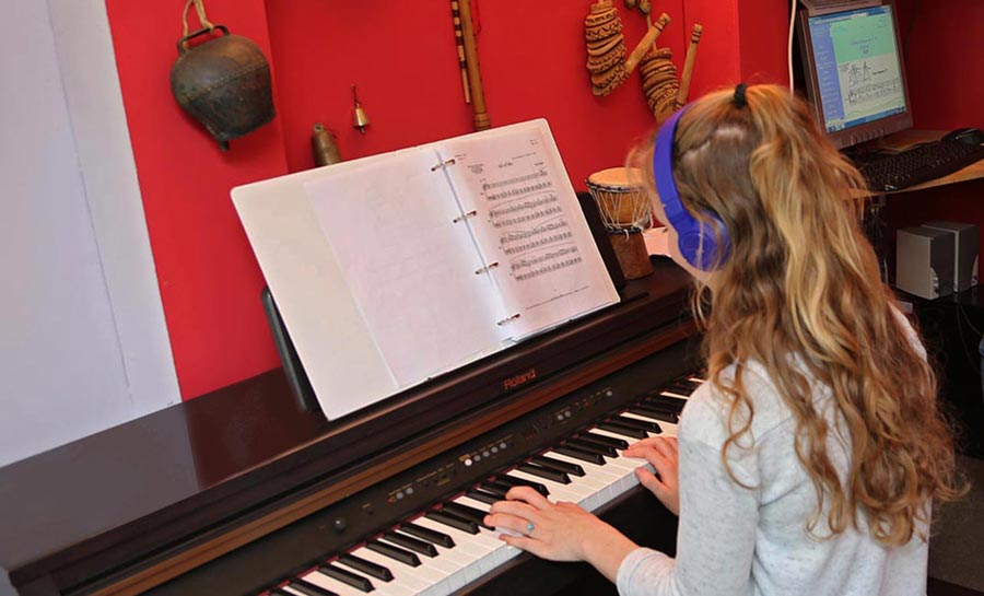 Petite fille jouant du piano lors d'un cours à l'école Régis Bonneel