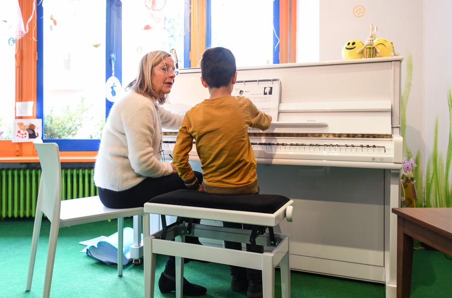 Professeure apprenant à un enfant à lire les notes de solfège