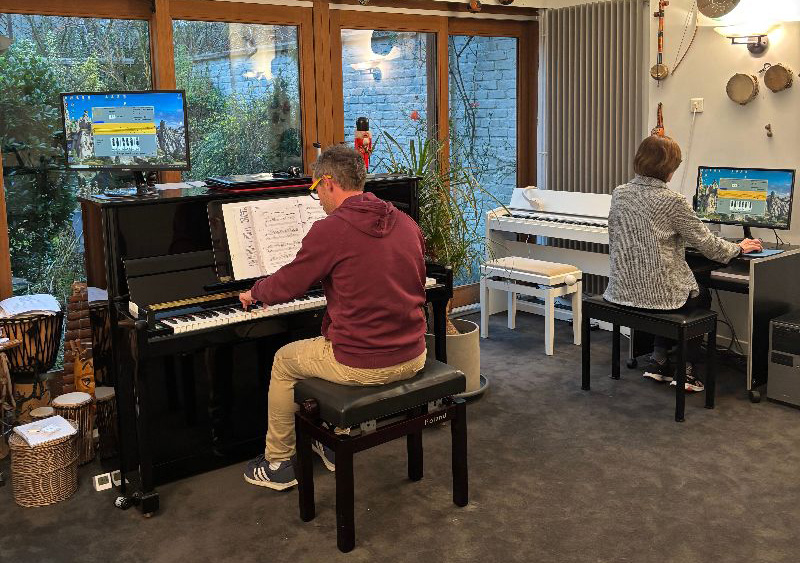 Deux personnes en train d'apprendre le piano